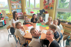 Grupa dzieci pięcioletnich wraz ze studentkami IV roku pedagogiki przedszkolnej i wczesnoszkolnej podczas wykonywania pracy plastycznej. Od lewej Martyna Jelonek, Natalia Gogół, Agnieszka Gola.