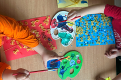 Malowanie makaronowych prac przez grupę dzieci pięcioletnich 