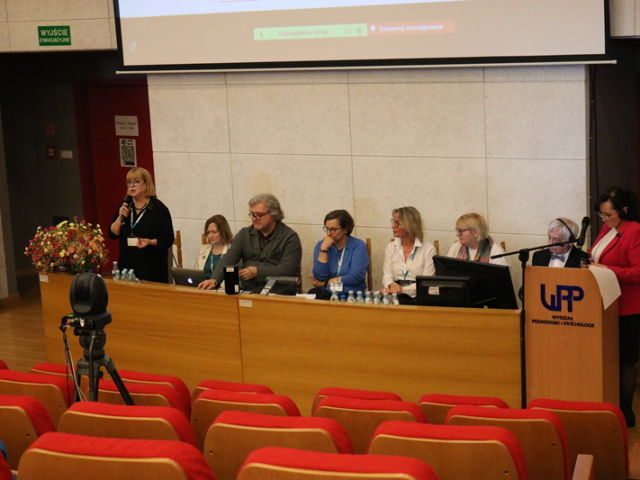 Od strony prawej znajdują się: Profesor Alina Wróbel, Profesor Bogusław Śliwerski, Profesor Erika Kopp, Proesor Renata Michalak, Profesor Hanna Kędzierska, Doktor Roman Shyyan, Profesor Olena Shyyan. Doktor Leah Shagrir zabiera głos w dyskusji.