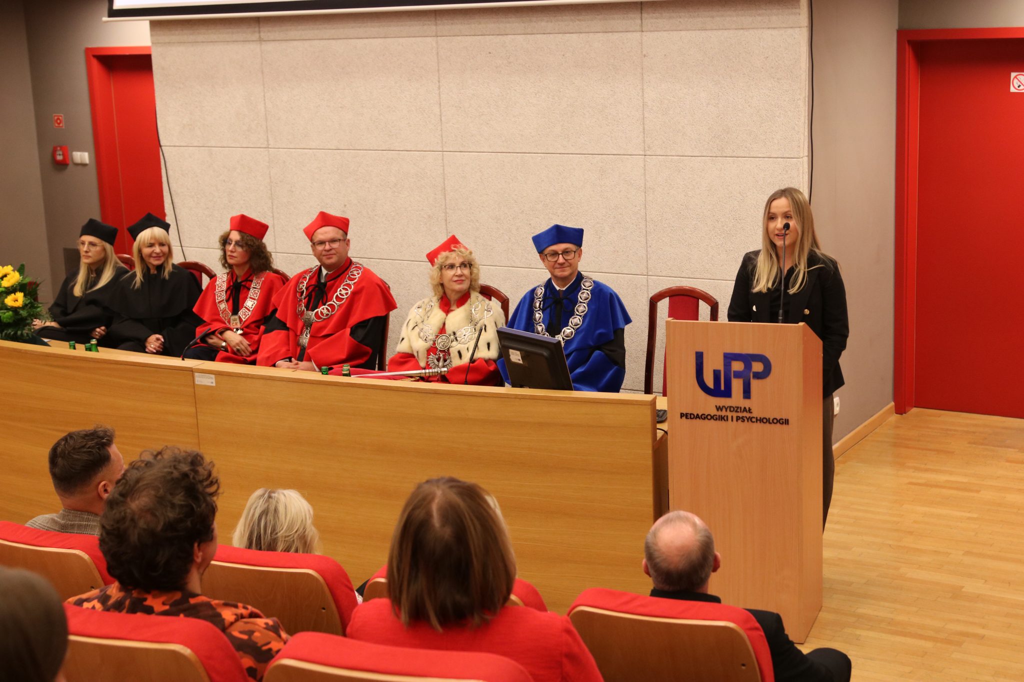 Studentka przy mównicy w obecności władz akademickich i uczestników inauguracji roku akademickiego 2026/2027 na WPP UJK.